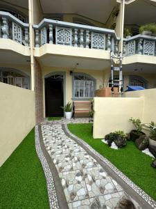 a house with a green lawn in front of it at Carmela Haven Inn in Baler