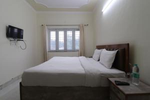 a bedroom with a large bed and a window at Hotel RP Residency in Nakraunda