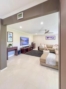 a living room with a couch and a tv at Solis Acreage Escape in Advancetown