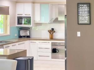 a kitchen with white cabinets and a stove top oven at Solis Acreage Escape in Advancetown +61 photos