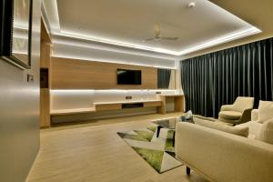 a living room with a couch and a tv at Kratos Lifestyle in Surat