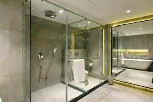 a bathroom with a glass shower and a sink at Kratos Lifestyle in Surat