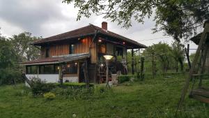 a small house on a hill with a green field at Мома Елена in Makhalnitsi