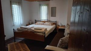 a bedroom with a bed and a couch in it at Мома Елена in Makhalnitsi