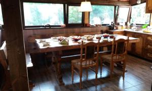 a kitchen with a wooden table and chairs in a room at Мома Елена in Makhalnitsi +15 photos