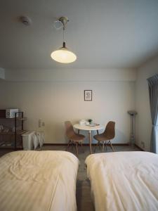 a room with two beds and a table and chairs at vetta kumamoto suizenji2 308 in Kumamoto