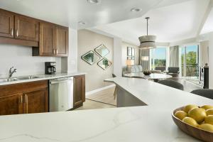 a kitchen and living room with a bowl of fruit on a counter at Marriott's Royal Palms in Orlando +31 photos
