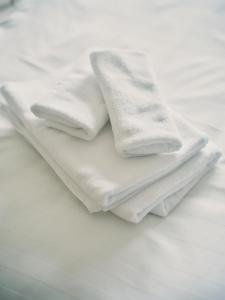three white towels sitting on top of a bed at vetta kumamoto suizenji2 308 in Kumamoto