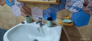 a bathroom sink with two cups on top of it at ToMa House in Pellaro +58 photos