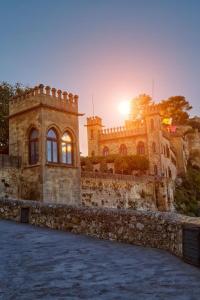 a stone building with the sun setting behind it at Castle House Xativa in Xàtiva