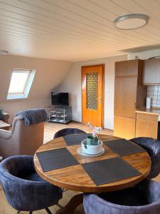 a living room with a wooden table and chairs at Ferienwohnung Weitblick in Großheide +19 photos