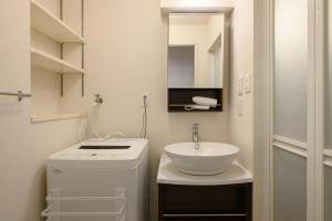 a small bathroom with a sink and a washing machine at Wilshire APT ホテル in Miyazaki +23 photos