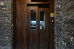 a wooden door with a sign on it at Wilshire APT ホテル in Miyazaki