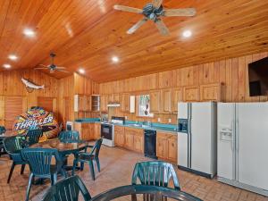 a kitchen with tables and chairs and a white refrigerator at Clear Creek Escape - Double Decker Dock, New Green Fishing Lights! in Jasper