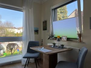 an office with a desk and two large windows at Appartement am Teich 2 in Krefeld