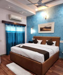 a bedroom with a large bed with a blue wall at New Mewar Darshan in Udaipur