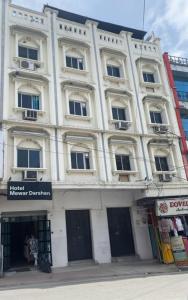 a large white building on a city street at New Mewar Darshan in Udaipur
