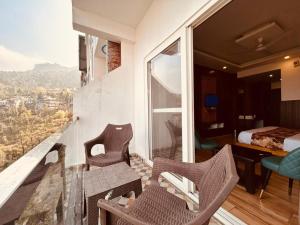 a room with a balcony with a view of a bedroom at Sawer Fan Resort in Mussoorie