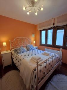 a bedroom with a white bed and a ceiling fan at As Pitas 1 in Tapia de Casariego