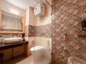 a bathroom with a shower with a toilet and a sink at Sawer Fan Resort in Mussoorie