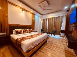 a bedroom with a bed and a flat screen tv at Sawer Fan Resort in Mussoorie