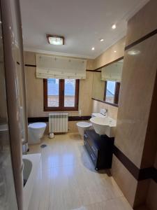 a large bathroom with two sinks and two toilets at As Pitas 1 in Tapia de Casariego
