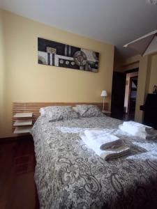 a bedroom with a bed with towels on it at As Pitas 1 in Tapia de Casariego +1 photo