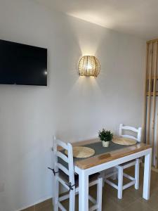 a dining room table with two chairs and a television at M&B Blue Beach in Son Xoriguer