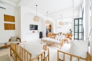 a living room with white walls and wooden chairs at 5BR Ocen View Villa in Jimbaran in Jimbaran
