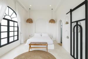 a white bedroom with a bed and a table at 5BR Ocen View Villa in Jimbaran in Jimbaran +36 photos