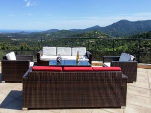 a patio with a table and two wicker chairs at Opulent Villa in Les Adrets de l Est rel in LʼÉglise