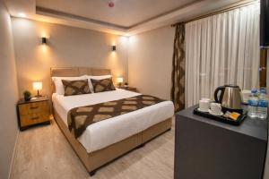 a bedroom with a bed and a dresser with a table at Whitestone Hotel in Nevşehir