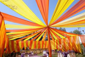 a large tent with tables and chairs under it at Hotel RP Residency in Nakraunda +21 photos