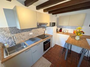 a kitchen with white cabinets and a sink and a counter at Le Duplex du Pont in Auxerre