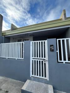 a blue house with a white door and gate at Log Horizon by The Guild Oasis Transient House in Rosario
