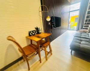 a wooden table and chair in a room with a couch at Pai Cheese cottage in Pai +8 photos