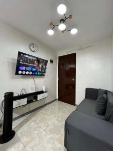 a living room with a couch and a tv on the wall at Log Horizon by The Guild Oasis Transient House in Rosario