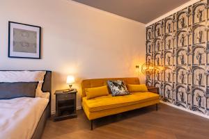 a bedroom with a yellow couch and a bed at Family Apartment History 5 Gäste Air Condition Parken Frei in Munich