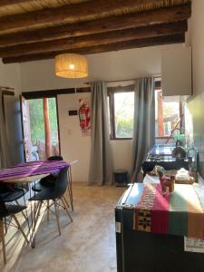 a living room with a table and a dining room at La Amanecida Tilcara Cabañas in Tilcara