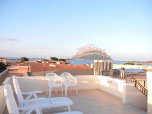 a balcony with chairs and a view of the ocean at Guesthouse La Locanda - Comfy Rooms & Local Food in Porto San Paolo