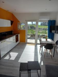 a kitchen with a table and a dining room at Chez Sophie, au calme, climatisé, proche d'Aix-les-bains in Grésy-sur-Aix