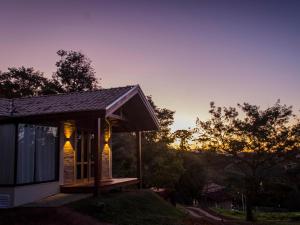 a small house with lights on it at sunset at Doce Refugio in Santo Antônio do Pinhal