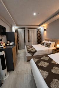 a hotel room with two beds and a television at Whitestone Hotel in Nevşehir