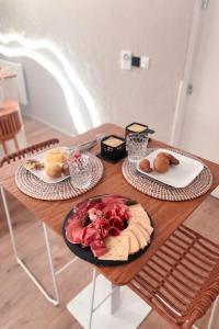a wooden table with two plates of food on it at Les Jolies Nuits - À la folie, Loft & Spa in Montrevault +15 photos