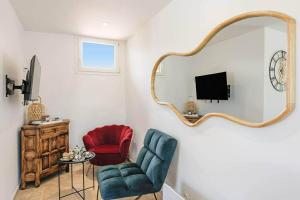 a living room with a chair and a mirror at Les cinq soleils in Roquebrune-sur-Argens