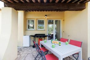 a white table with red chairs and a ping pong table at Les cinq soleils in Roquebrune-sur-Argens