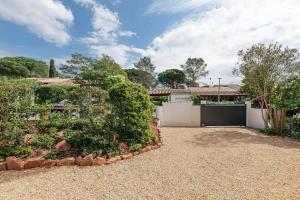 a house with a white fence and a yard at Les cinq soleils in Roquebrune-sur-Argens