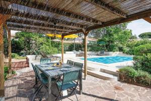 a patio with a table and chairs and a pool at Les cinq soleils in Roquebrune-sur-Argens