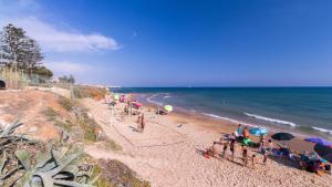 a group of people sitting on a beach with umbrellas at Argo apartment, fronte mare, kaucana beach in Villaggio Azzurro