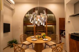 a dining room with a table with chairs and a chandelier at SUNZ ROOMS -naha miebashi- in Naha
